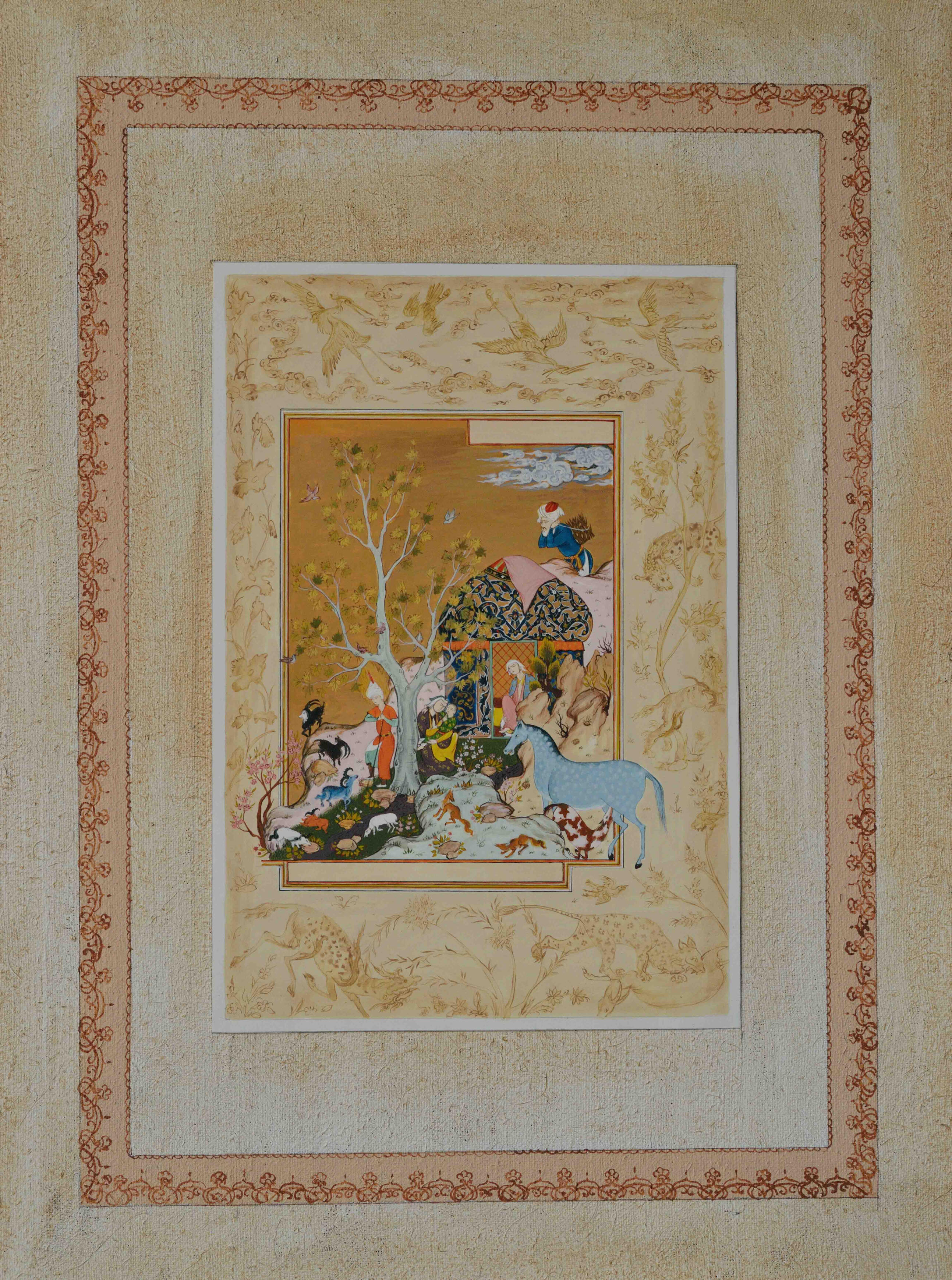 Photo of Olim Kamolzoda sitting at the desk in his workshop. He is the Honoured Artist of the Republic of Tajikistan, a Member of the Union of Artists of the Republic of Tajikistan, and a Specialist of the Miniature Art. Studying the specifics of the work